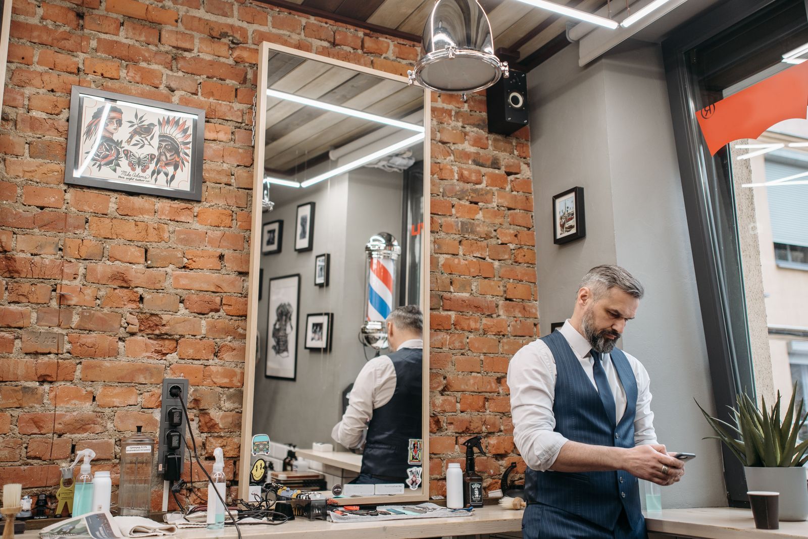 Coiffeur consultant son téléphone dans son salon