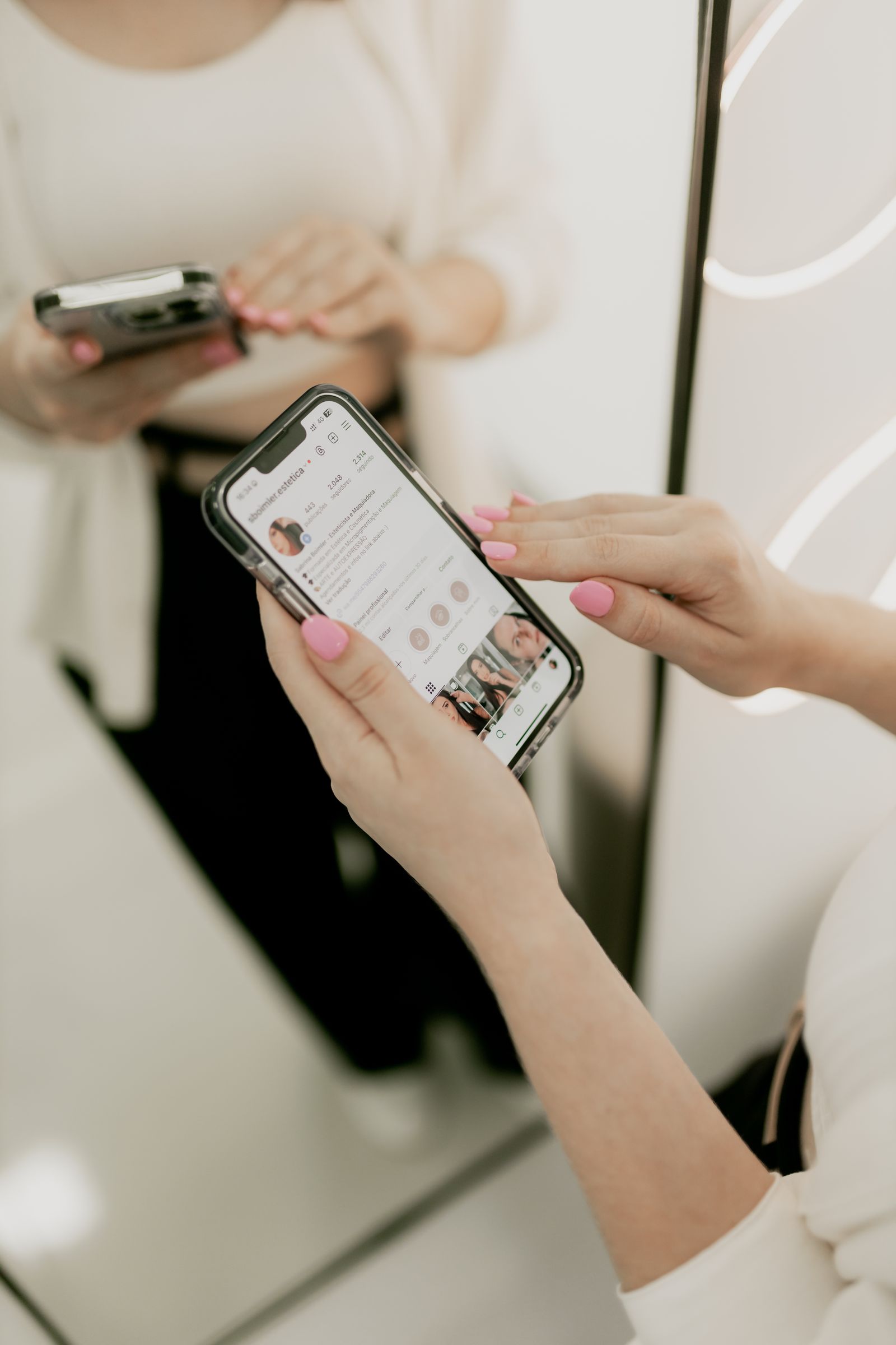 Prothésiste ongulaire consultant un profil Instagram sur son téléphone